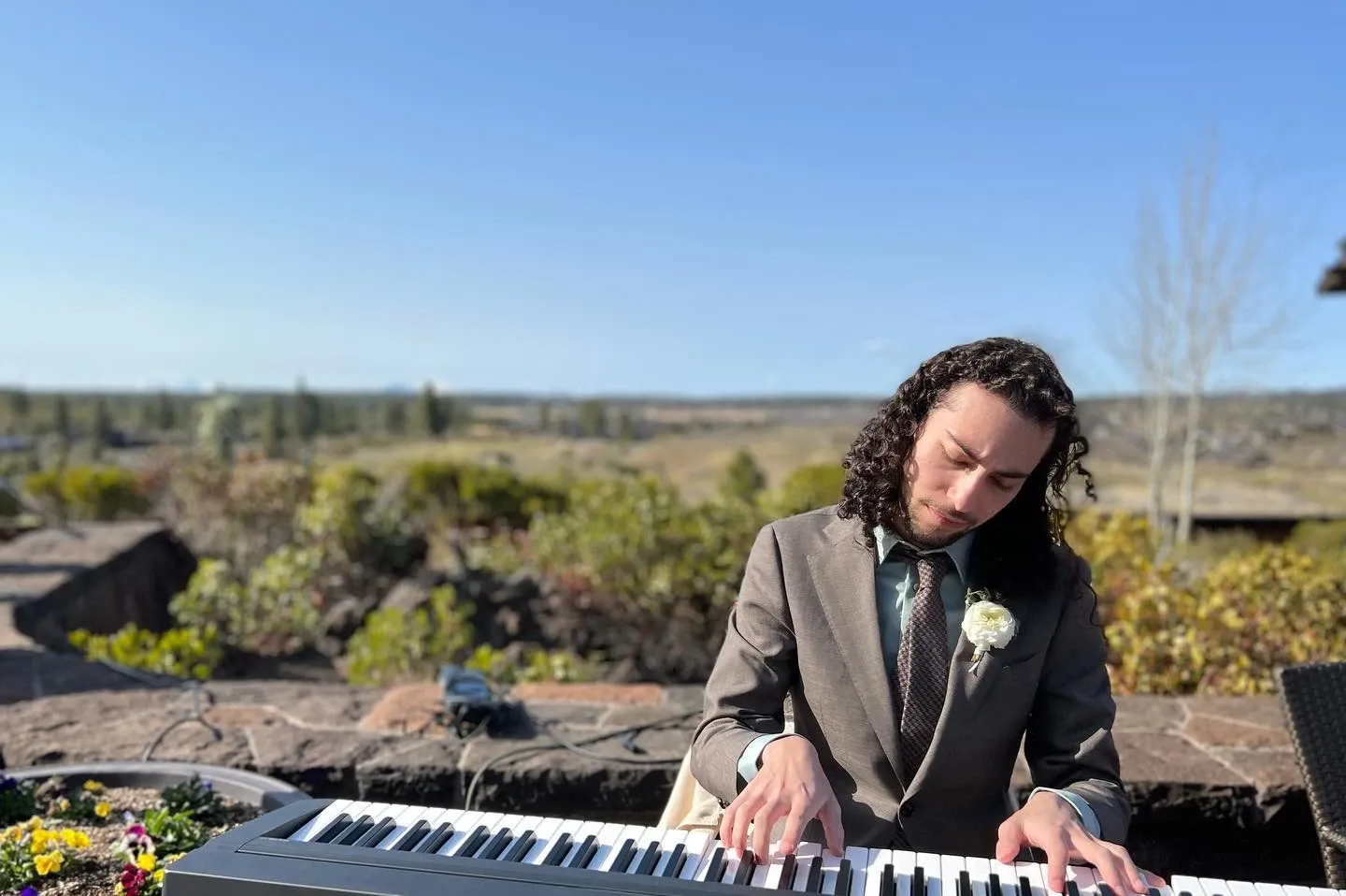 Gabe playing a keyboard at an outdoor wedding